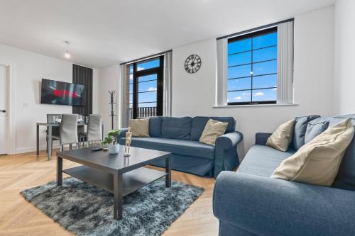 a living room with a blue couch and a table at Stylish 2-Bed - Rooftop Views - Central Birmingham in Birmingham