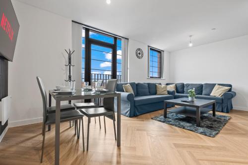 a living room with a table and a blue couch at Stylish 2-Bed - Rooftop Views - Central Birmingham in Birmingham