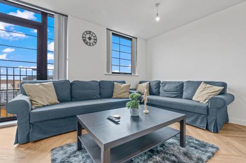 a living room with a blue couch and a table at Stylish 2-Bed - Rooftop Views - Central Birmingham in Birmingham