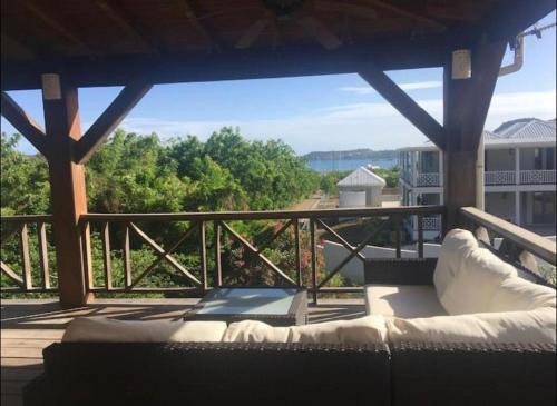 a porch with a couch on a deck with a view at Monks Hill Villa in Falmouth