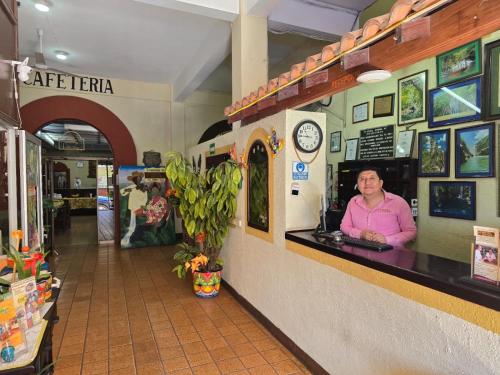 a woman sitting at a counter in a store at Hotel Riviera in Ciudad Valles