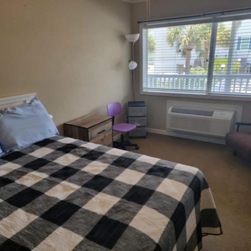 a bedroom with a bed and a desk and a window at Coco Loco in Myrtle Beach