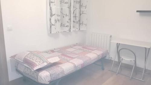 a bed in a room with a desk and a table at Apartamento La Rueda in Olite