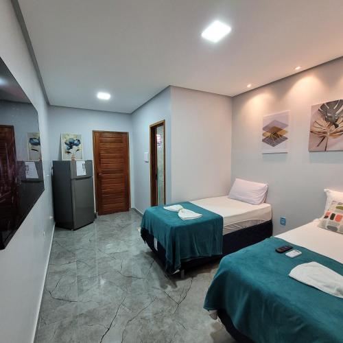 a room with two beds and a television in it at Flat 10 Mobiliado 4 min do aeroporto pousada loft Marabá in Marabá