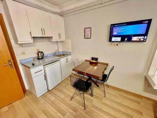 a kitchen with a table and chairs and a tv on the wall at Deluxe Vista Suit Hotel Taksim in Istanbul