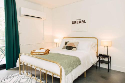a bedroom with a white bed with a gold frame at *NEW* - The Coretta: Downtown | Walkable | Rooftop in Atlanta