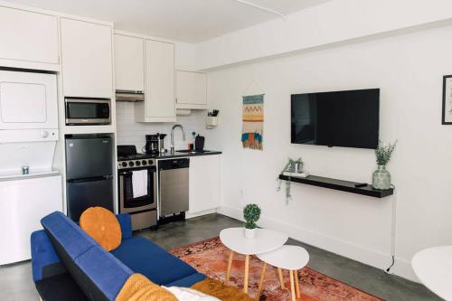 a living room with a blue couch and a kitchen at *NEW* - The Coretta: Downtown | Walkable | Rooftop in Atlanta