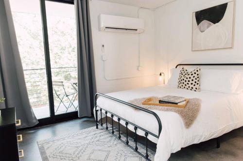 a bedroom with a bed with a table on it at <THE MYLO> Walkable | Rooftop | Skyline | Dreamy in Atlanta
