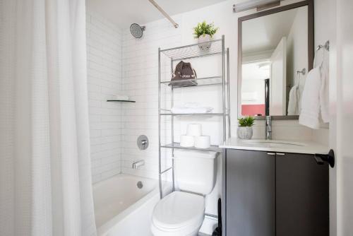 a white bathroom with a toilet and a sink at <THE MYLO> Walkable | Rooftop | Skyline | Dreamy in Atlanta