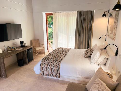 a bedroom with a bed and a desk and a television at Fina Estampa Country Hotel by HMC - Mayores de 10 años - in Támesis