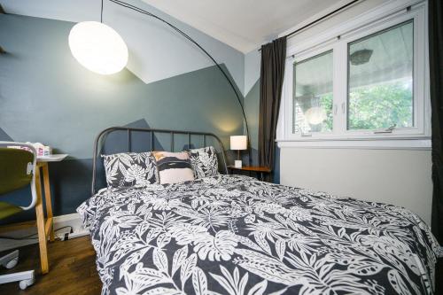 a bedroom with a black and white bed and a window at Spacious Room with Ensuite Bathroom near Subway, Koreatown & UofT in Toronto