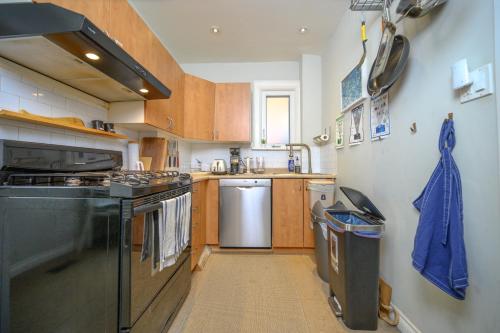 a small kitchen with a stove and a dishwasher at Spacious Room with Ensuite Bathroom near Subway, Koreatown & UofT in Toronto