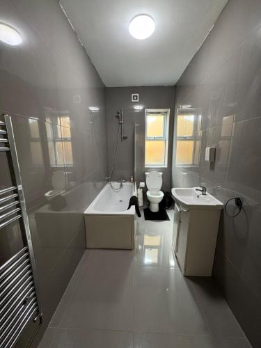 a bathroom with a tub and a toilet and a sink at Tranquil 1BR in Gravesend in Gravesend