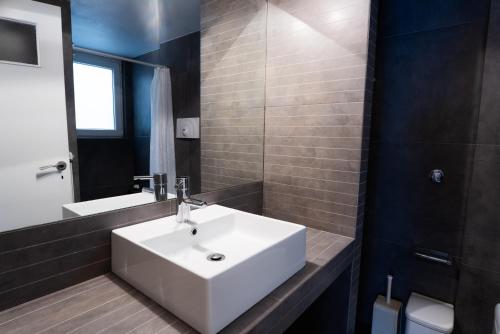 a bathroom with a white sink and a mirror at Syntagma square, 60sqm Fancy apartment in Athens
