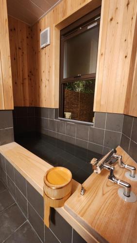y baño con aseo de madera y lavamanos. en Mina's LanternHouse, en Takayama