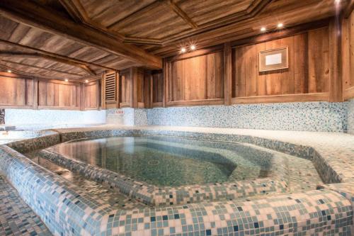 - une grande piscine dans une chambre dotée de plafonds en bois dans l'établissement Les Chalets Du Gypse - LES CHALETS DU GYPSE A04 MAE-3861, à Saint-Martin-de-Belleville
