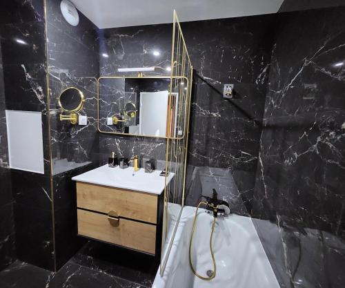 a black bathroom with a sink and a tub at Appartement Basilique 4 chambres tout confort Saint Denis in Saint-Denis