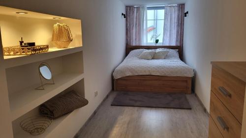 a small bedroom with a bed and a mirror at Apartament w Lubomierzu in Lubomierz