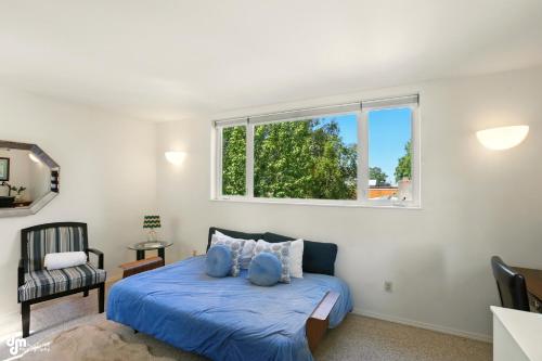 a bedroom with a blue bed and a window at Coastal Place - BEST location in Downtown! in Anchorage