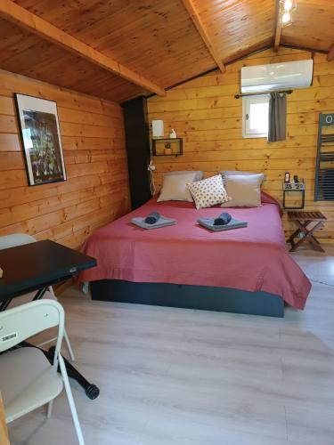 a bedroom with a bed in a wooden cabin at Le Châlet des Hortillonnages in Amiens