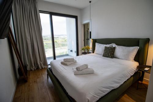 ŻebbuġにあるPenthouse Magic Gozo Stargazeのタオルが敷かれた大きなベッドのある寝室