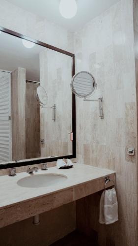 a bathroom with a sink and a large mirror at Hotel San Felipe in Oaxaca City