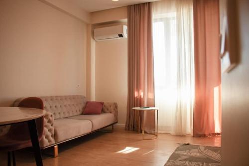 a living room with a couch in front of a window at Apartment for daily rent in Tbilisi City