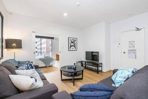 a living room with a couch and a table at 504 - Perth CBD Huge 1BR 1BA Beauty in Perth