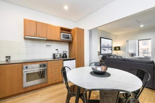 a kitchen and a living room with a table and chairs at 504 - Perth CBD Huge 1BR 1BA Beauty in Perth
