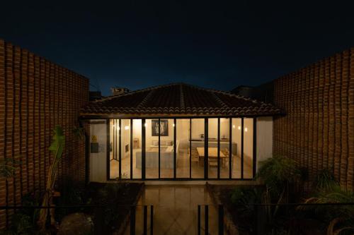 a house with a lot of windows on it at night at Jungla Hotel Boutique in San Cristóbal de Las Casas