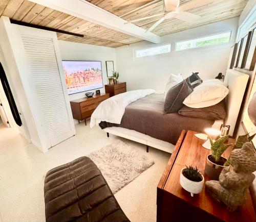 a bedroom with a bed and a flat screen tv at Zachs Siesta Key Beach House Heated Saltwater Pool Pet Friendly in Siesta Key
