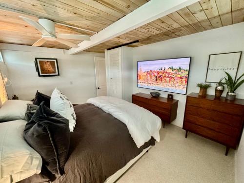 a bedroom with a bed and a flat screen tv at Zachs Siesta Key Beach House Heated Saltwater Pool Pet Friendly in Siesta Key