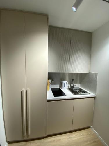 a kitchen with white cabinets and a stove at Studio8 centerapartment Prizren in Prizren