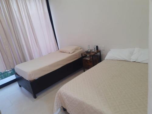 a bedroom with two beds and a window at Casa Herrera in Santa Cruz Huatulco
