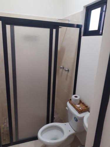 a bathroom with a toilet and a shower with a window at Casa Herrera in Santa Cruz Huatulco