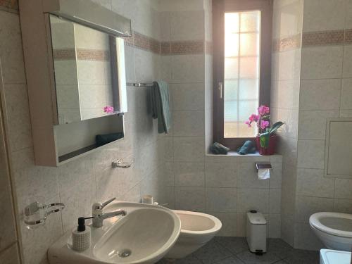 a bathroom with a sink and a toilet and a mirror at Casa al Sasso in Bellinzona