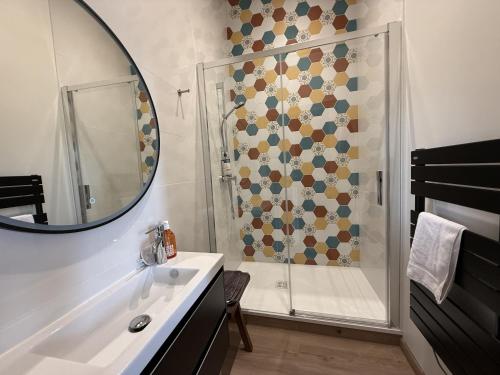 un bagno con doccia, lavandino e specchio di Chateau de Resteau Haut de Gamme 15 pers a Maigné