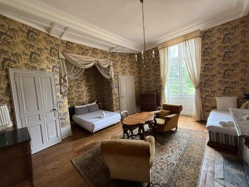 un soggiorno con un letto e un tavolo di Chateau de Resteau Haut de Gamme 15 pers a Maigné
