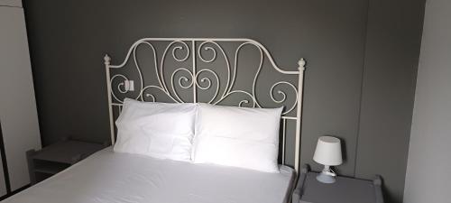 a bed with a metal headboard and white pillows at Αλέξανδρος 6 in Mirina