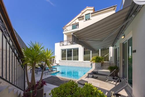 a house with a swimming pool next to a building at Hotel - Teranea City Hvar in Hvar