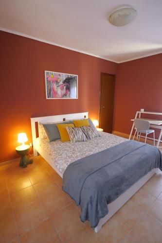 a bedroom with a large bed with red walls at Maison dans la rue in Gassino Torinese