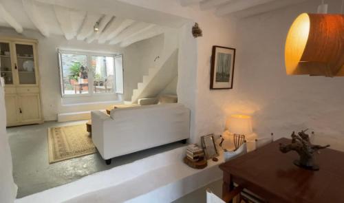 a living room with a white couch and a window at Casa Tohca Setenil in Setenil