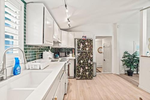 - une cuisine avec des placards blancs, un évier et une porte dans l'établissement Quiet Cottage In The Woods, On A Country Road, à Glenmoore