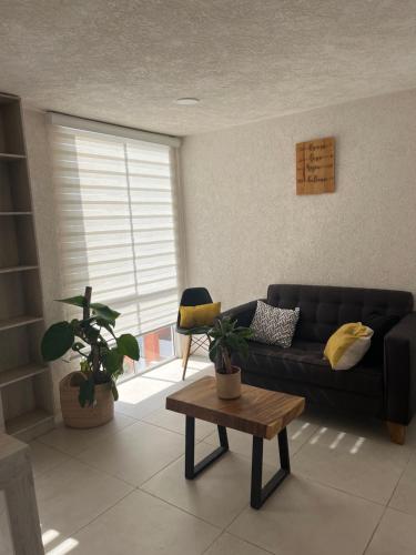 a living room with a couch and a table at Departamento equipado in Tonalá