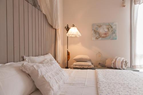 a bedroom with a white bed and a lamp at La Pulcia B&B in Gradara