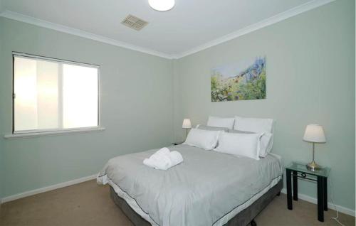 a white bedroom with a bed and a window at 40 Modern & Chic Apt In East Perth in Perth