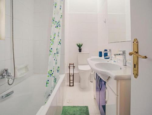 a bathroom with a sink and a toilet and a shower at Villa Kazantzaki in Athens