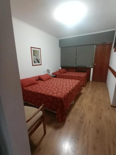 a bedroom with two beds with red comforters at Dr Cesar Carman in Cordoba