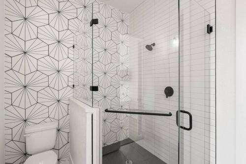 ein schwarz-weißes Bad mit einem WC und einer Dusche in der Unterkunft White Dove Pool House- Modern Luxury 4br Home Near Lake Travis Wpool in Austin