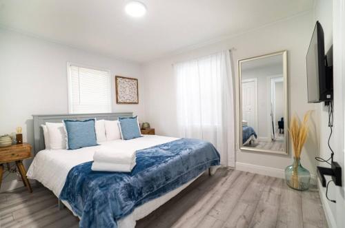 a bedroom with a bed with blue and white pillows at Homey Cozy Newly Renovated Stylish&chic in Tampa